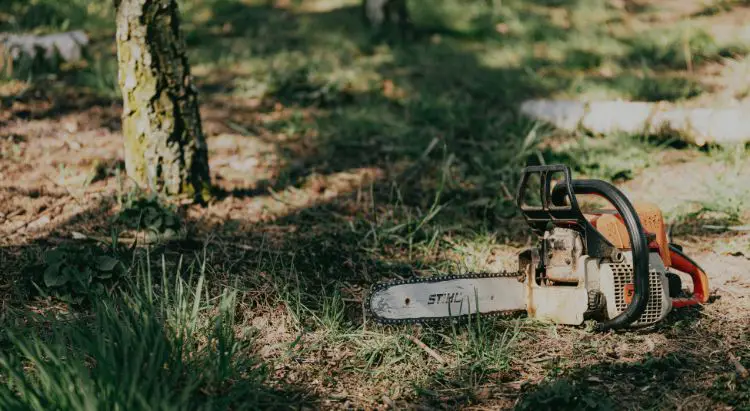 A stihl chainsaw resting on the ground